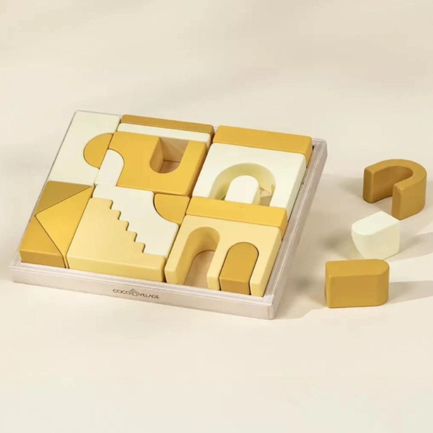 Set of yellow geometric wooden blocks with a clear plastic tray on a beige background