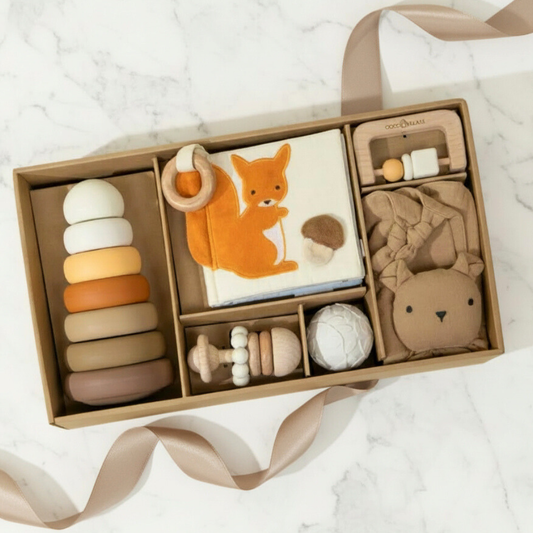 Collection of baby toys in a box on a white marble surface