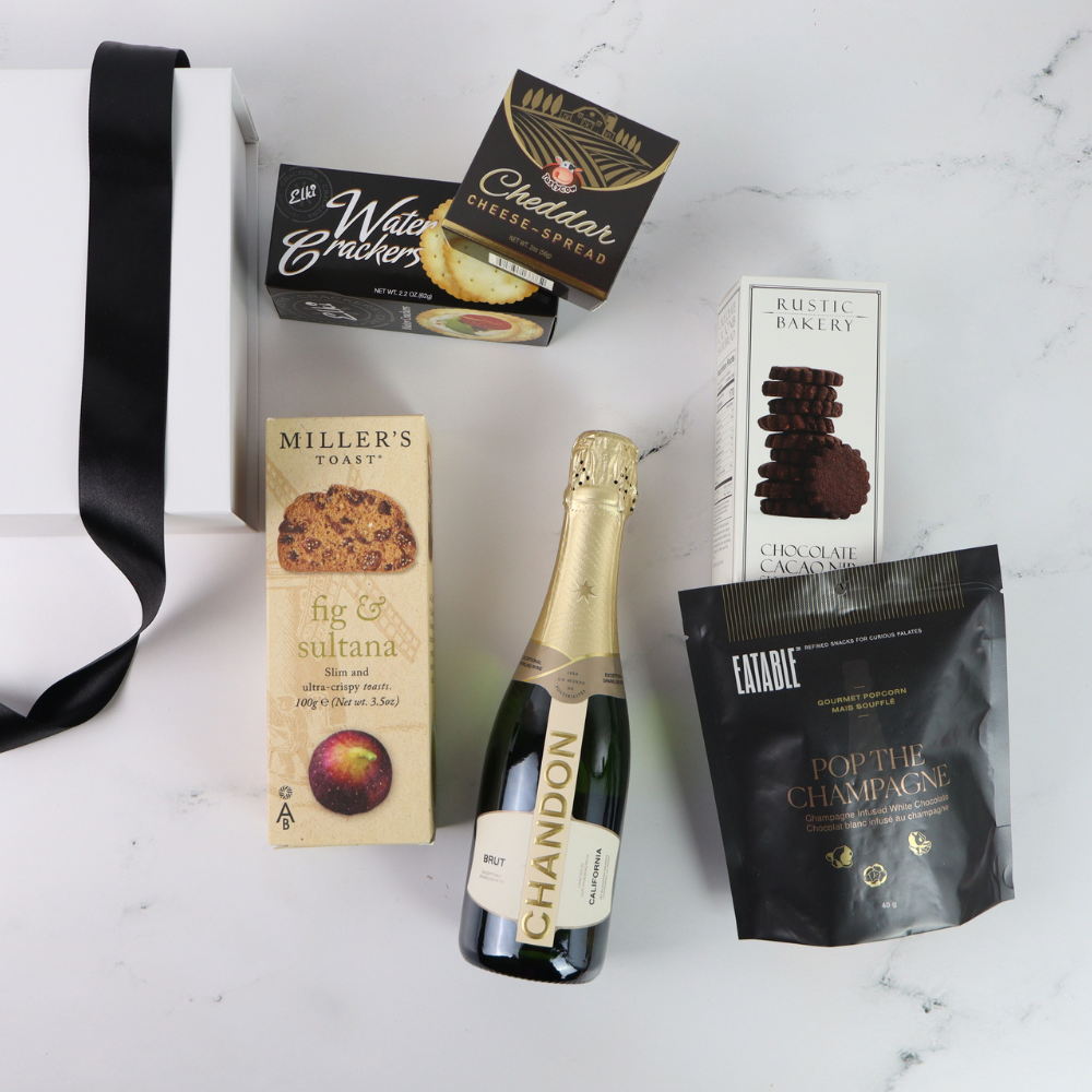 Bottle of Chandon champagne with assorted snacks on a white surface