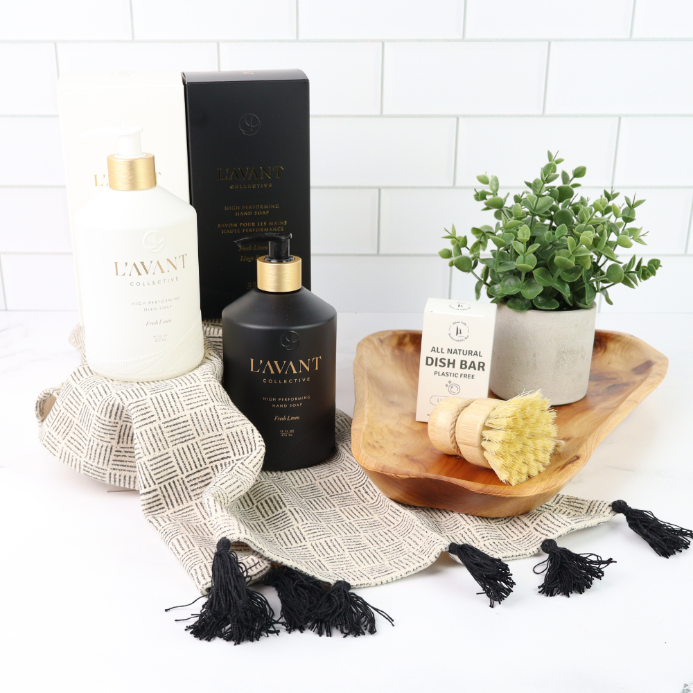 L'AVANT products including bottles, a dish bar, and a plant on a white surface with a tiled wall background.
