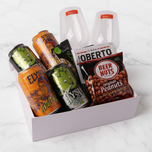 Gift basket with beer, snacks, and drinks on a white surface