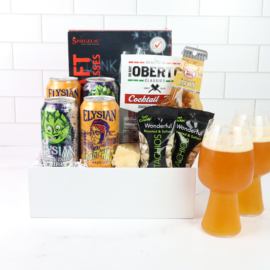 Gift basket with Elysian beer cans, cocktail mix, and snacks on a white background