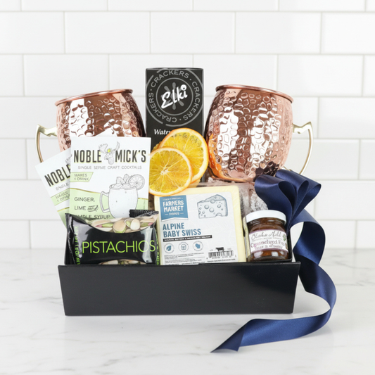 moscow mule Gift basket with snacks, mugs, and a jar of jam on a white background