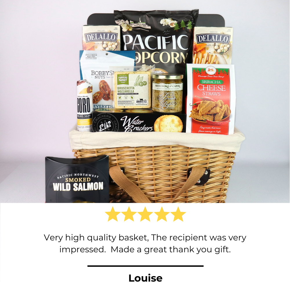 Wicker gift basket with various snacks and a wild salmon package on a light gray background.