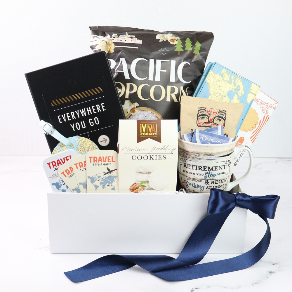 retirement Gift basket with travel-themed items including a mug, cookies, and books on a white background