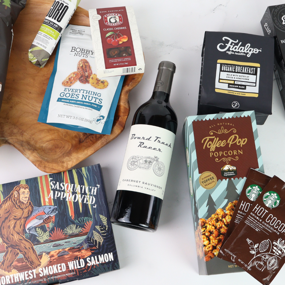 Assorted food products including a bottle of wine, snacks, and packaged goods on a white surface.