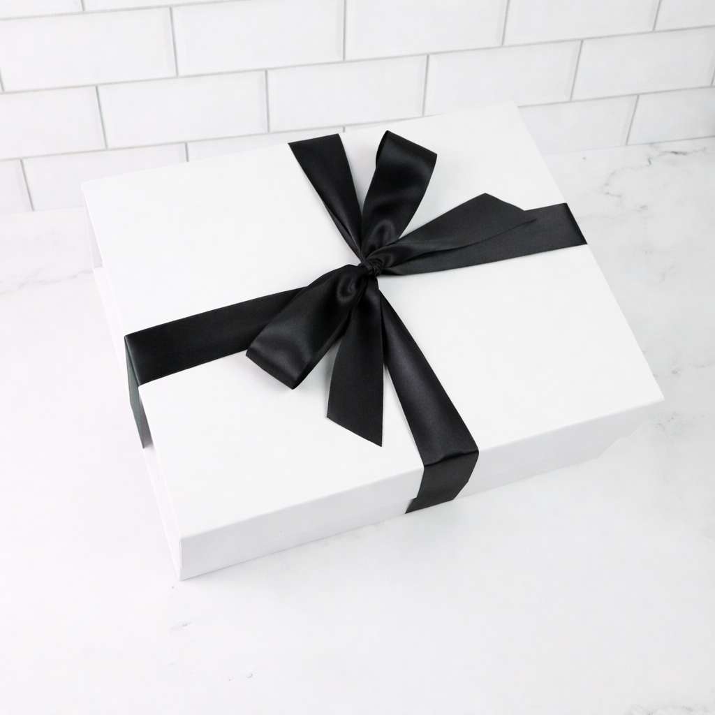 White gift box with a black ribbon on a white background