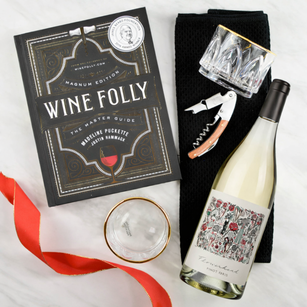 Wine bottle, 'Wine Folly' book, glasses, and corkscrew on a white background